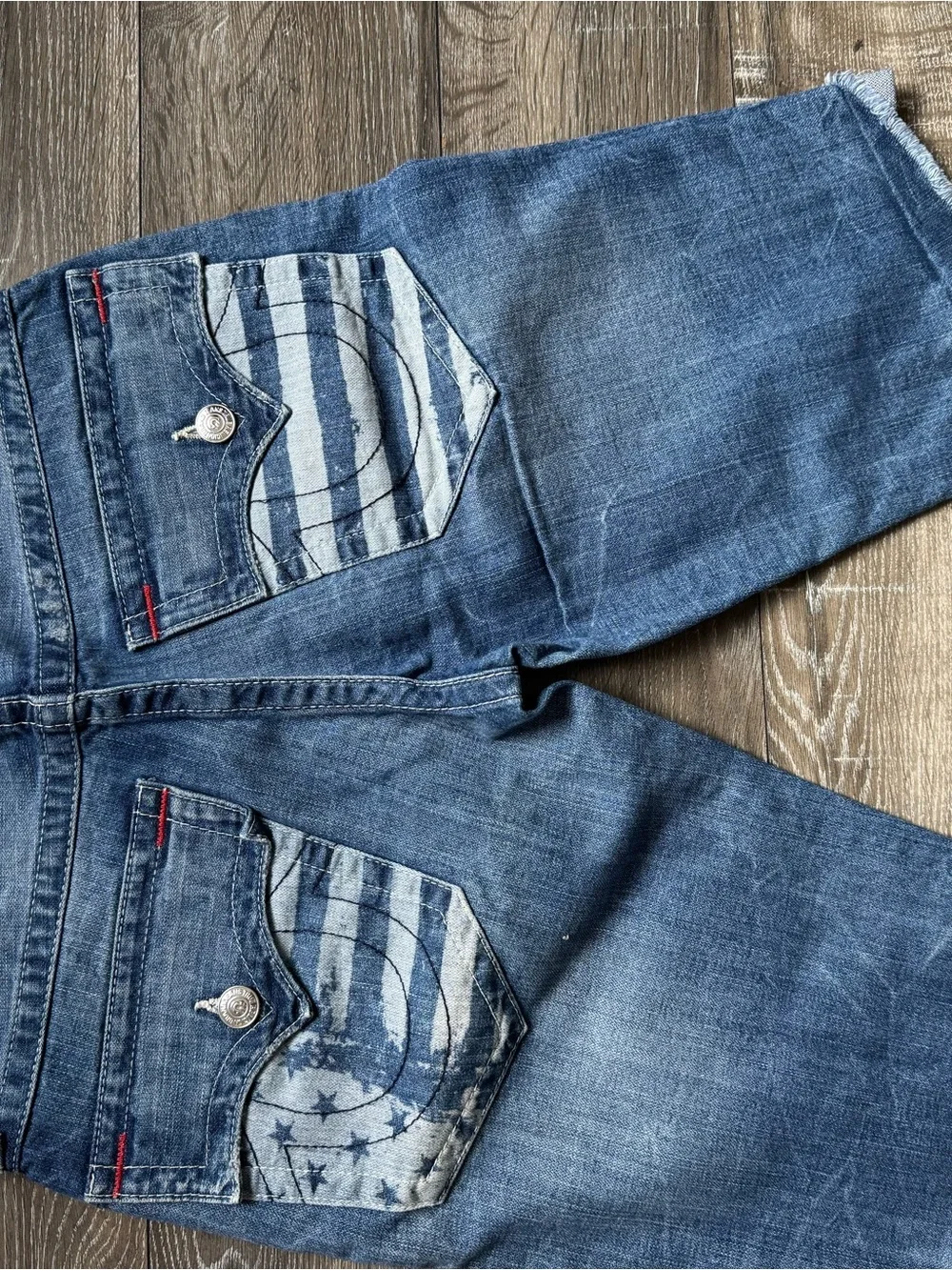 True Religion medium blue denim cutoff shorts with red logo patch